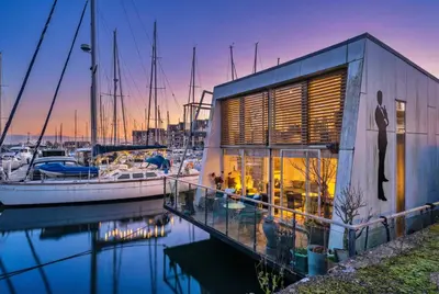 a house with a marina with boats in the water at Finest Retreats - The Houseboat, Liverpool Marina in Liverpool