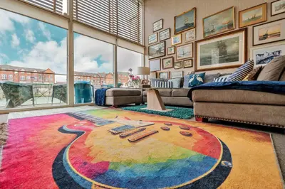 a living room with a rainbow rug on the floor at Finest Retreats - The Houseboat, Liverpool Marina in Liverpool