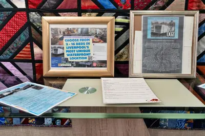 a table with two pictures and a book on it at Finest Retreats - The Houseboat, Liverpool Marina in Liverpool