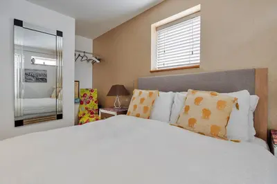 a bedroom with a white bed with pillows and a window at Finest Retreats - The Houseboat, Liverpool Marina in Liverpool