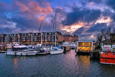 a group of boats docked in a harbor with buildings at Finest Retreats - The Houseboat, Liverpool Marina in Liverpool