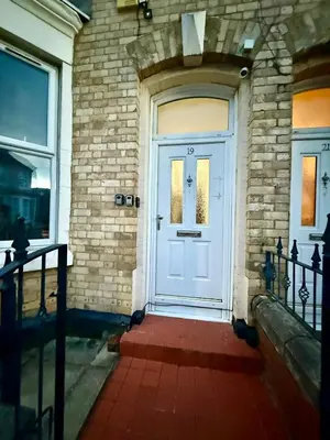 a white front door of a brick building at The Coningsby Staycation in Liverpool