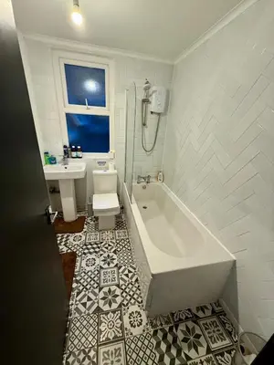 a white bathroom with a tub and a sink at The Coningsby Staycation in Liverpool