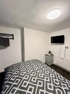 a bedroom with a bed and a flat screen tv at The Coningsby Staycation in Liverpool