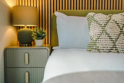 a bedroom with a bed and a lamp on a night stand at Luxury 2-Bed Apt by Royal Albert Dock & M&S Arena in Liverpool