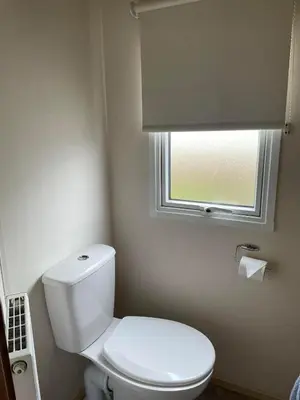 a bathroom with a white toilet and a window at Shellie's Summer Breeze Retreat in Heysham