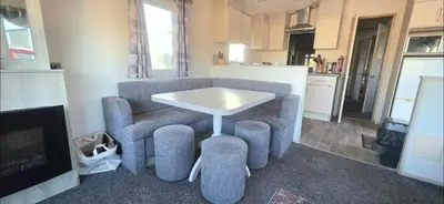 a living room with a table and a kitchen at Shellie's Summer Breeze Retreat in Heysham