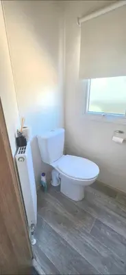 a bathroom with a white toilet and a window at Shellie's Summer Breeze Retreat in Heysham