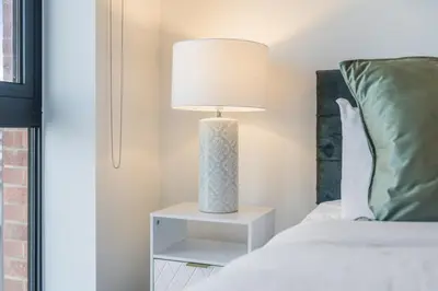 a lamp on a night stand next to a bed at Oriel Residence - 2BR - 4 Beds - Sleeps 5 in Liverpool