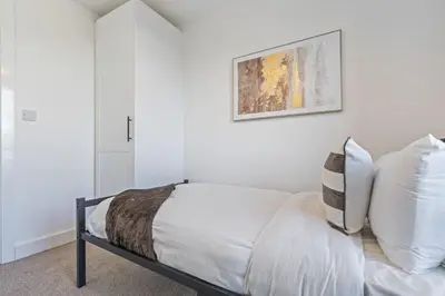 a bedroom with white walls and a bed with white pillows at Oriel Residence - 2BR - 4 Beds - Sleeps 5 in Liverpool
