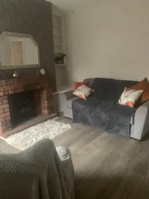 a living room with a couch and a fireplace at 2 bedroom house in Horwich