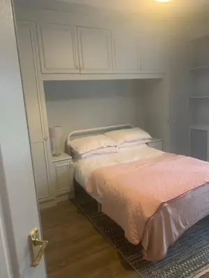 a bedroom with a bed with white cabinets at 2 bedroom house in Horwich