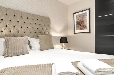 a bedroom with a large bed with a large headboard at Abbey Apartments - Modern Serviced Apartments - Tourists & Professionals in Barrow in Furness