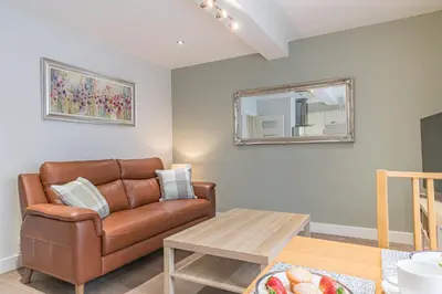 a living room with a couch and a table at Abbey Apartments - Modern Serviced Apartments - Tourists & Professionals in Barrow in Furness