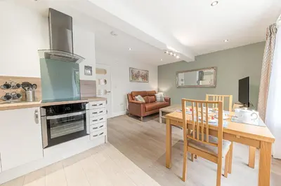 a kitchen and dining room with a table and a stove at Abbey Apartments - Modern Serviced Apartments - Tourists & Professionals in Barrow in Furness