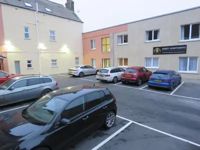 a group of cars parked in a parking lot at Abbey Apartments - Modern Serviced Apartments - Tourists & Professionals in Barrow in Furness