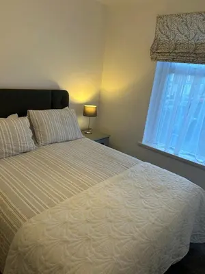a bedroom with a large bed with a window at Beautiful 3 bedroom home, Dorrington Terrace in Lancaster