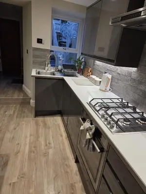 a kitchen with a sink and a stove top oven at May Cottage, Ulverston in Greenodd