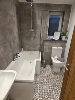 a bathroom with a tub and a toilet and a sink at May Cottage, Ulverston in Greenodd
