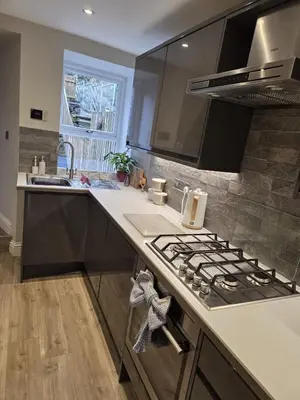 a kitchen with a stove top oven next to a sink at May Cottage, Ulverston in Greenodd