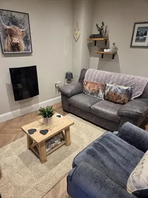 a living room with a couch and a coffee table at May Cottage, Ulverston in Greenodd