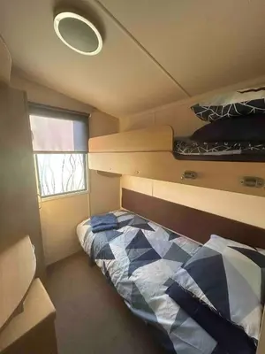 a small bedroom with a bed and a window at Charming Holiday Park Retreat in Morecambe - Family-Friendly Escape in Morecambe