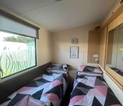 two beds in a room with a window at Charming Holiday Park Retreat in Morecambe - Family-Friendly Escape in Morecambe