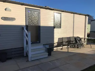 a house with a porch with chairs and a door at Charming Holiday Park Retreat in Morecambe - Family-Friendly Escape in Morecambe