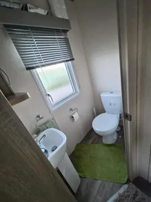 a small bathroom with a toilet and a sink at 3 bed family caravan r12 in Heysham