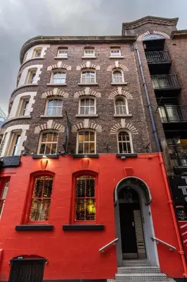 a red brick building with a red door at Stylish Studio Apartment in Liverpool