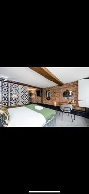 a bedroom with a large white bed and a tv at Stylish Studio Apartment in Liverpool