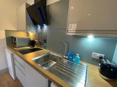 a kitchen with a sink and a microwave at Avenham Apartments in Preston