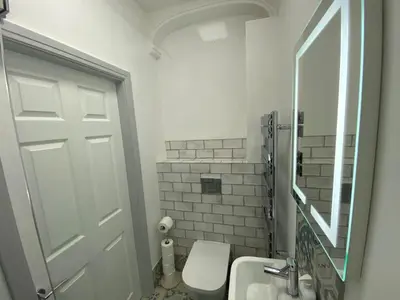 a bathroom with a toilet and a sink and a mirror at Avenham Apartments in Preston