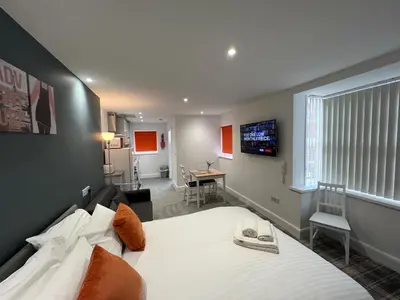 a bedroom with a large bed and a living room at Avenham Apartments in Preston