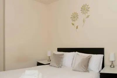 a bedroom with a bed with white sheets and pillows at Avenham Apartments in Preston