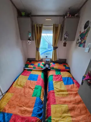 two beds in a small room with a window at Hill family residence in Morecambe