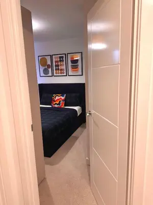 a small bedroom with a black bed and some pictures at Room in Blackburn - Peters Place in Lower Darwen
