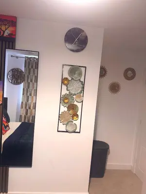a wall with a clock and a picture of shells at Room in Blackburn - Peters Place in Lower Darwen