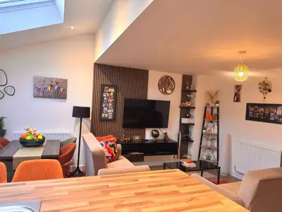 a living room with a couch and a tv at Room in Blackburn - Peters Place in Lower Darwen