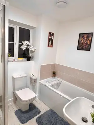 a bathroom with a toilet and a tub and a sink at Room in Blackburn - Peters Place in Lower Darwen