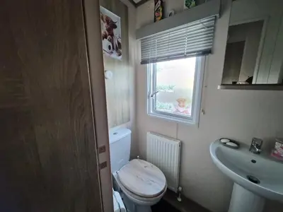 a small bathroom with a toilet and a sink at Hills residence in Morecambe