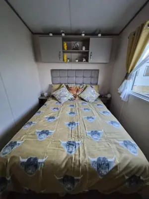 a bedroom with a large bed with blue flowers on it at Hills residence in Heysham