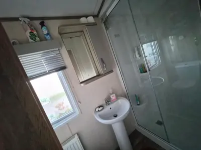 a small bathroom with a sink and a shower at Hills residence in Heysham
