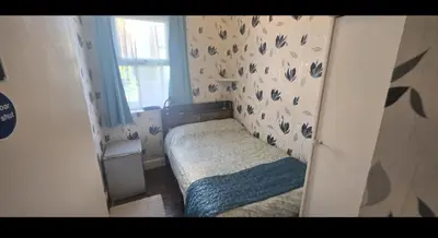 a small bed in a small room with a window at Blackburn Rooms in Blackburn