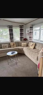 a living room with a large couch and a table at Trailer by the sea in Millom