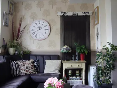 a living room with a couch and a clock on the wall at The Manhattan in Blackpool