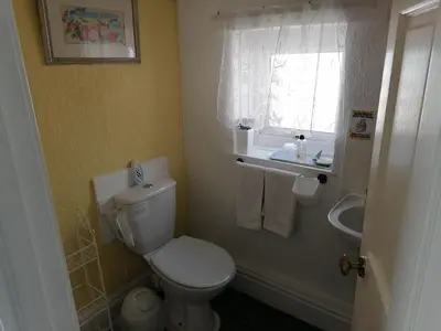 a bathroom with a toilet and a sink and a window at The Manhattan in Blackpool
