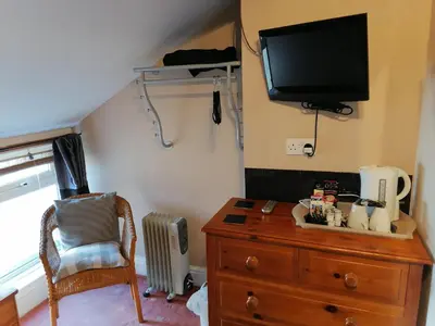 a room with a dresser and a tv and a chair at The Manhattan in Blackpool
