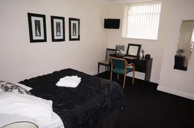 a bedroom with a bed and a desk with a computer at South Beach Apartments in Blackpool