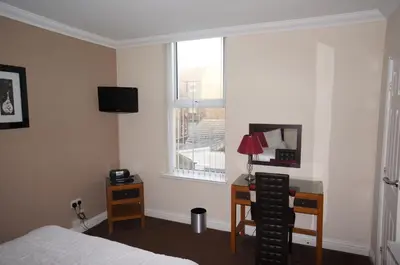 a bedroom with a bed and a desk and a window at South Beach Apartments in Blackpool